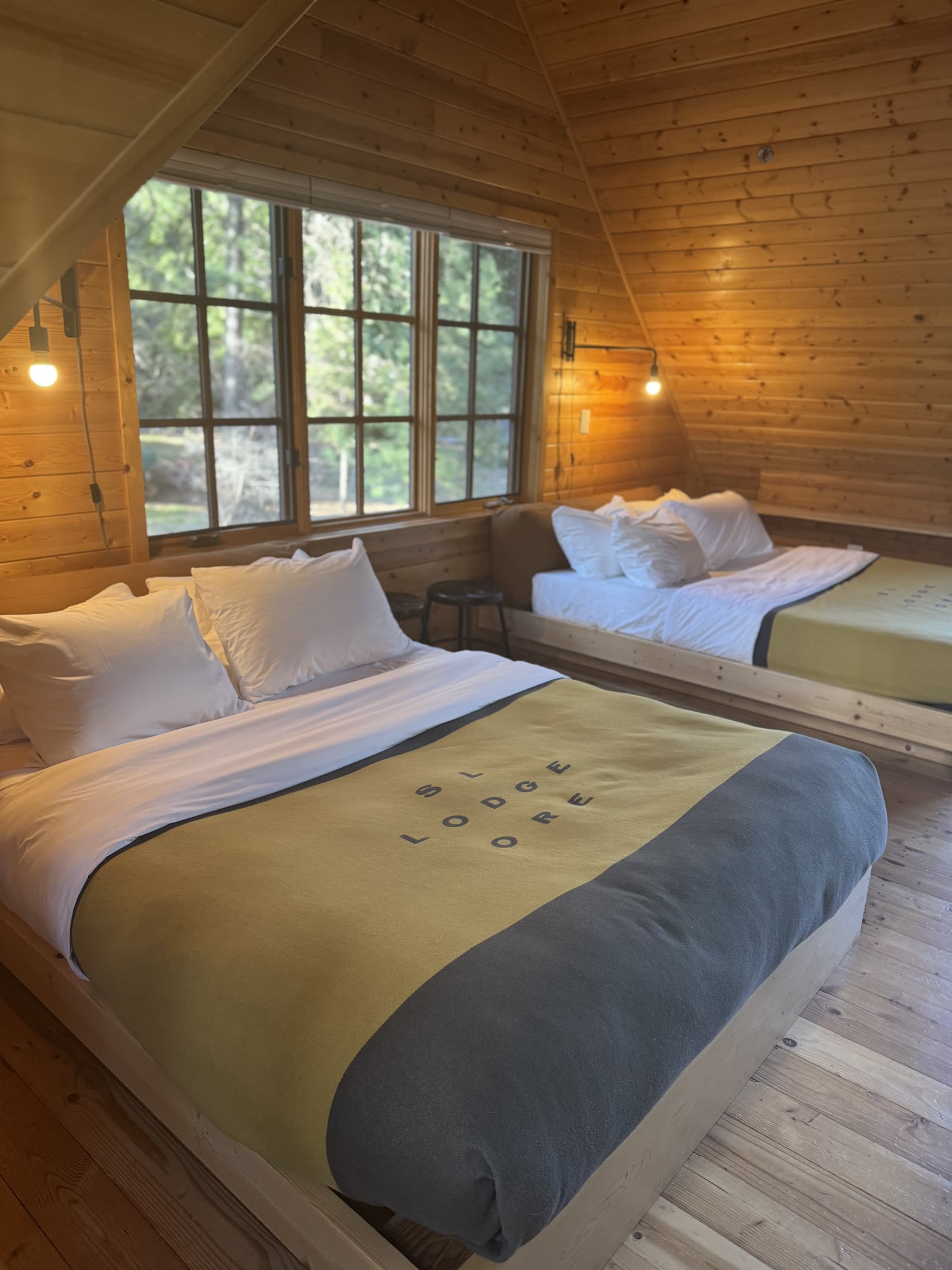Inside a lodge room with pine walls and lodge blankets