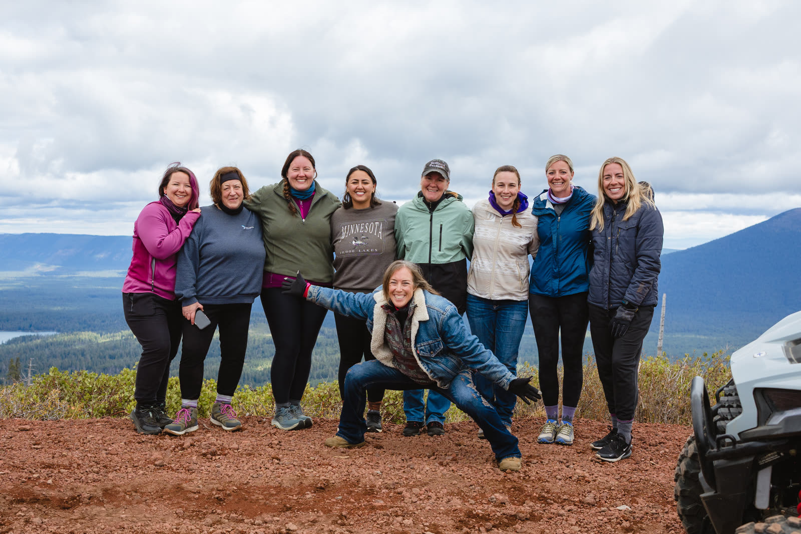 A group of retreat guests together on a ridge above the forest